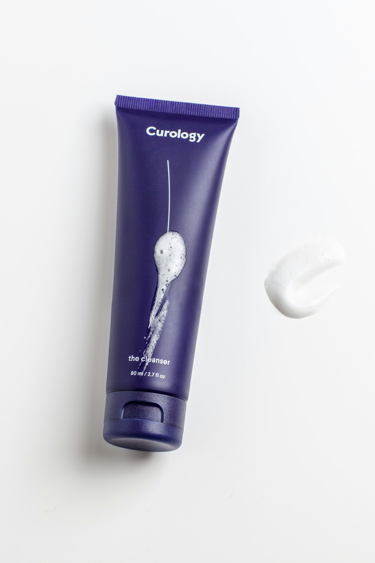 A cleanser bottle standing on folded linen — part of a prescribed eight-week acne home routine